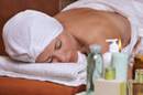 stock photo : Scented candles, oils, lotions creams and perfumes.   Focus on the woman.